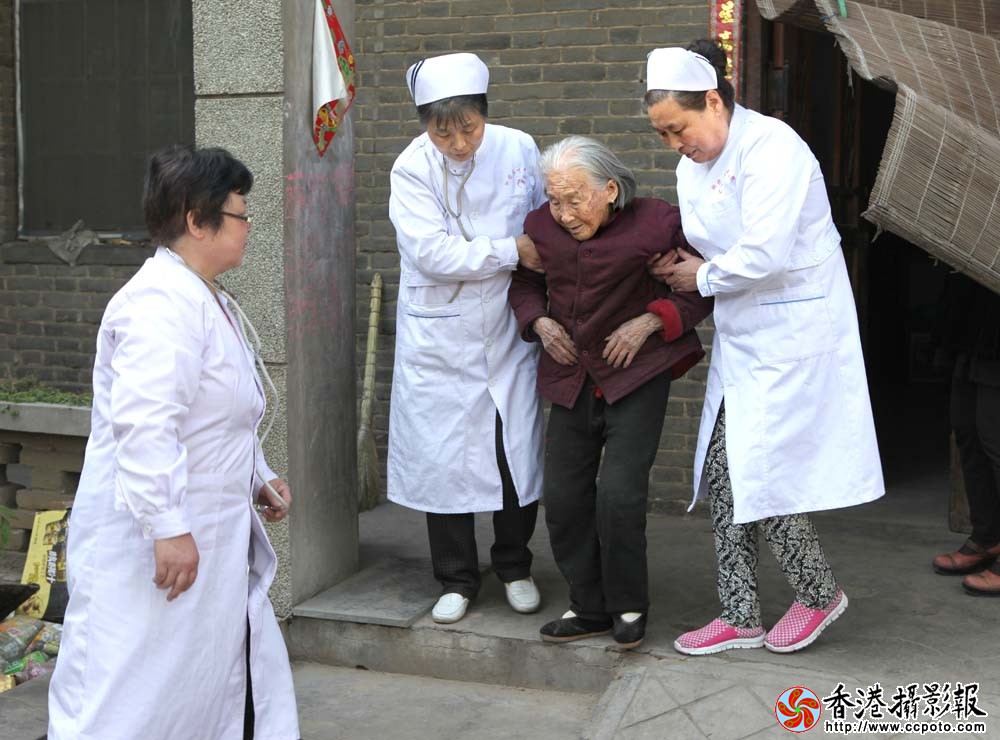 护士搀扶老人到院里走动.JPG